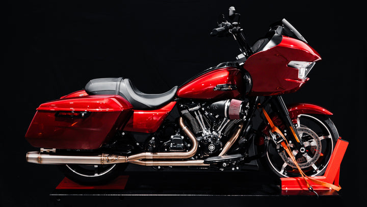 Red Harley M8 Bagger equipped with Sawicki Speed Intimidator exhaust on black backdrop.