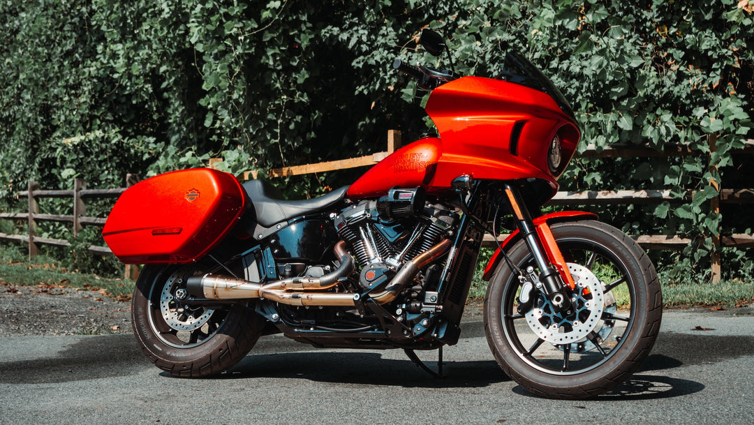 Red Harley-Davidson Softail Low Rider ST equipped with Sawicki Speed Shorty 2-into-1 exhaust parked on a road in front of trees.